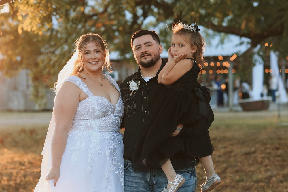 Family of three smiling at golden hour