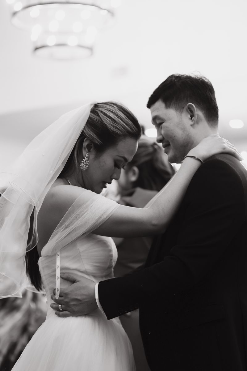 Bride and groom embracing at their reception, black and white